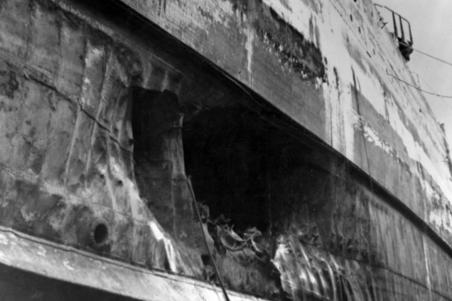 Torpedo damage to the hull of the USS California is seen at the Pearl Harbor Navy Yard in April 1942 after the ship had been dry-docked for repairs. (U.S. Navy photo)